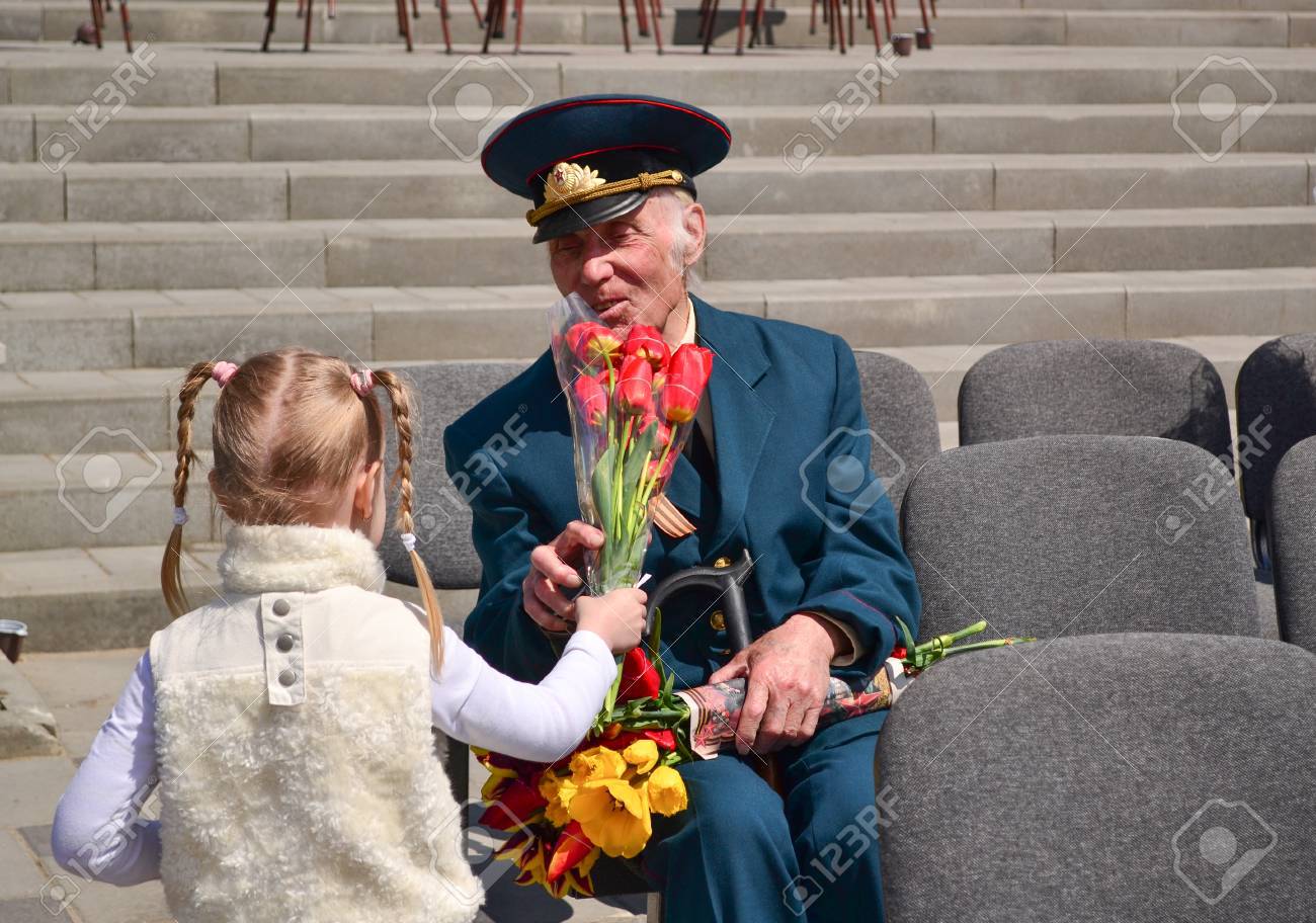 Мальчик дарит цветы ветерану